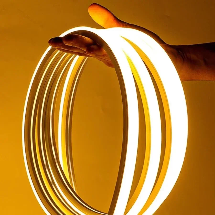 Flexible LED strip light emitting warm white glow, held in hand for home or commercial lighting