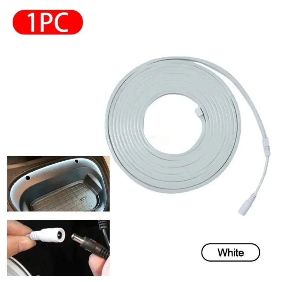 White LED strip light with DC connector, coiled for car interior lighting installation