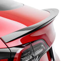 Carbon fiber rear spoiler on red sports car trunk, sleek aerodynamic design for performance styling