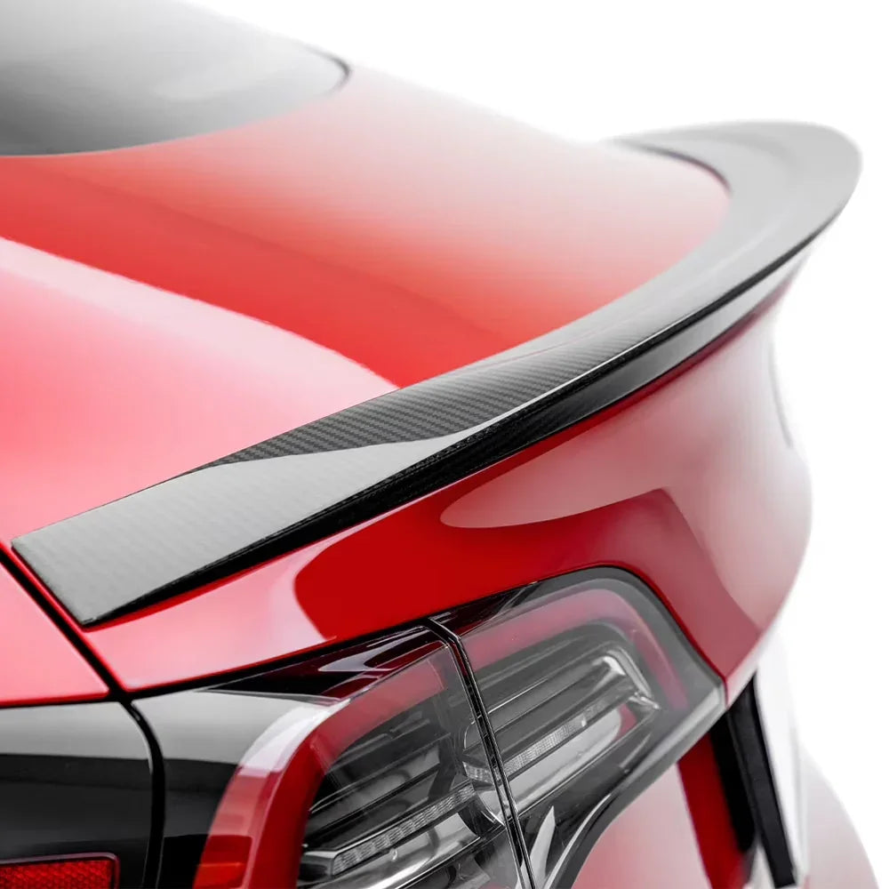 Carbon fiber rear spoiler on red sports car trunk, sleek aerodynamic design for performance styling