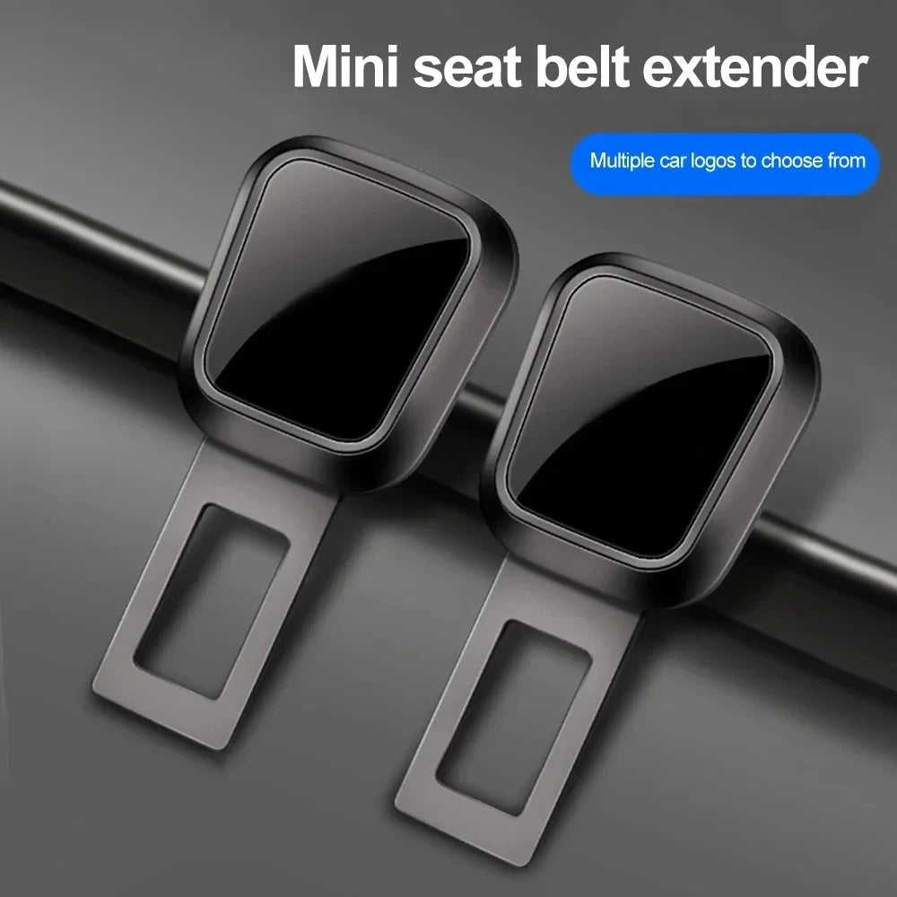 Two black metal seat belt extender clips on grey background