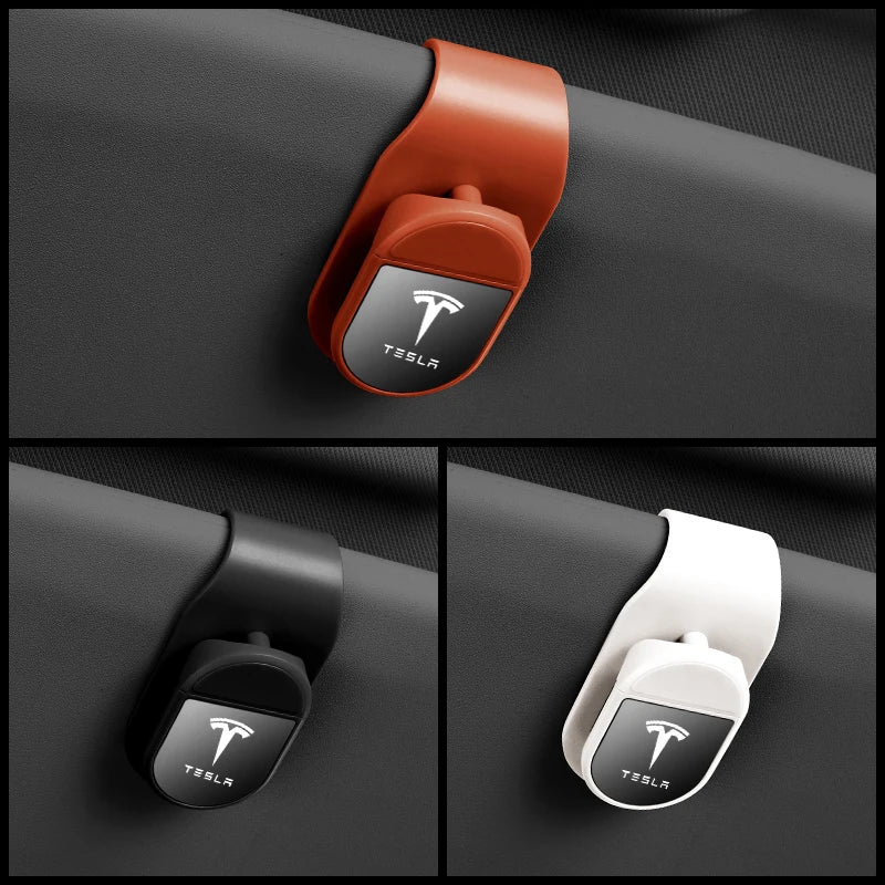 Tesla visor sunglasses clip shown installed in orange, black, and white