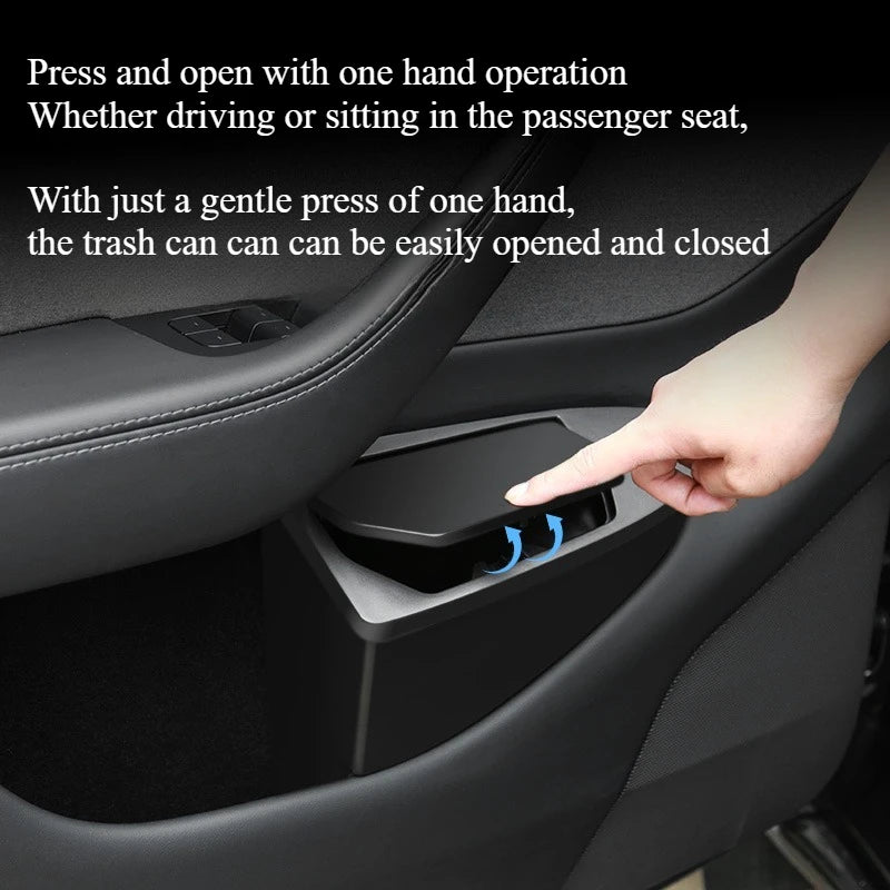 Hand pressing open Tesla Model Y front door trash can lid with one hand